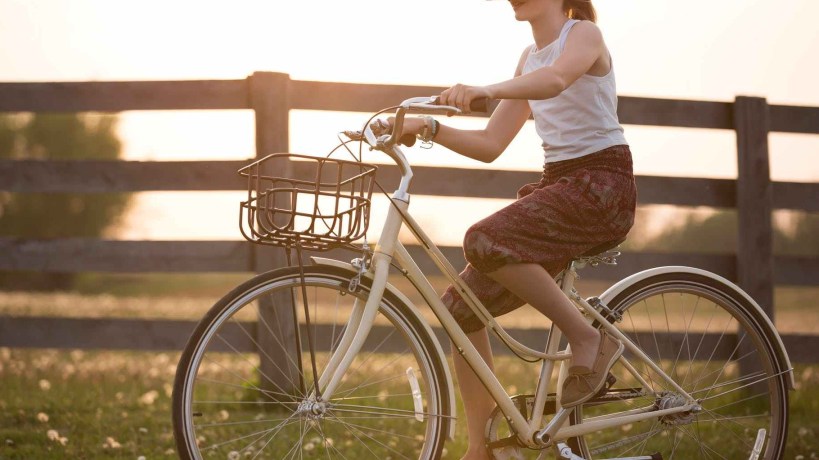 girl wearing vr box driving bicycle during golden hour